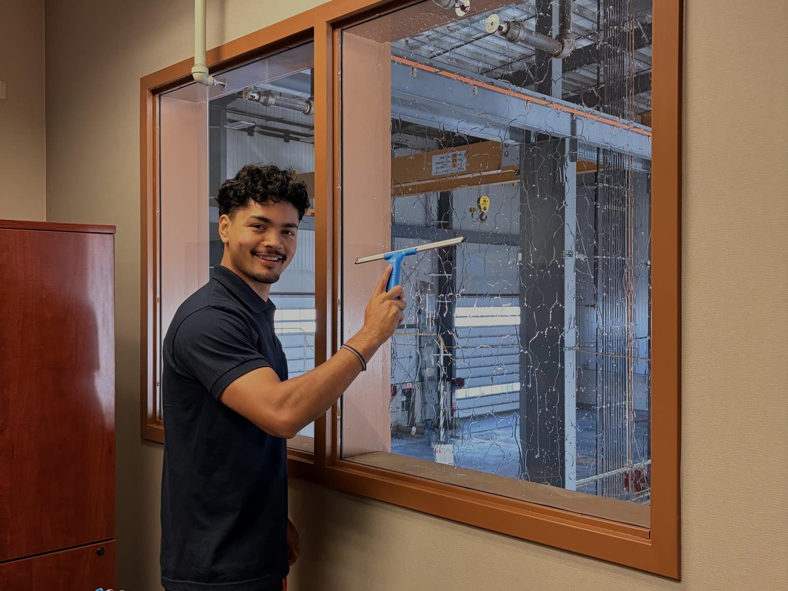 MTZ cleaner squeegeeing a large interior window